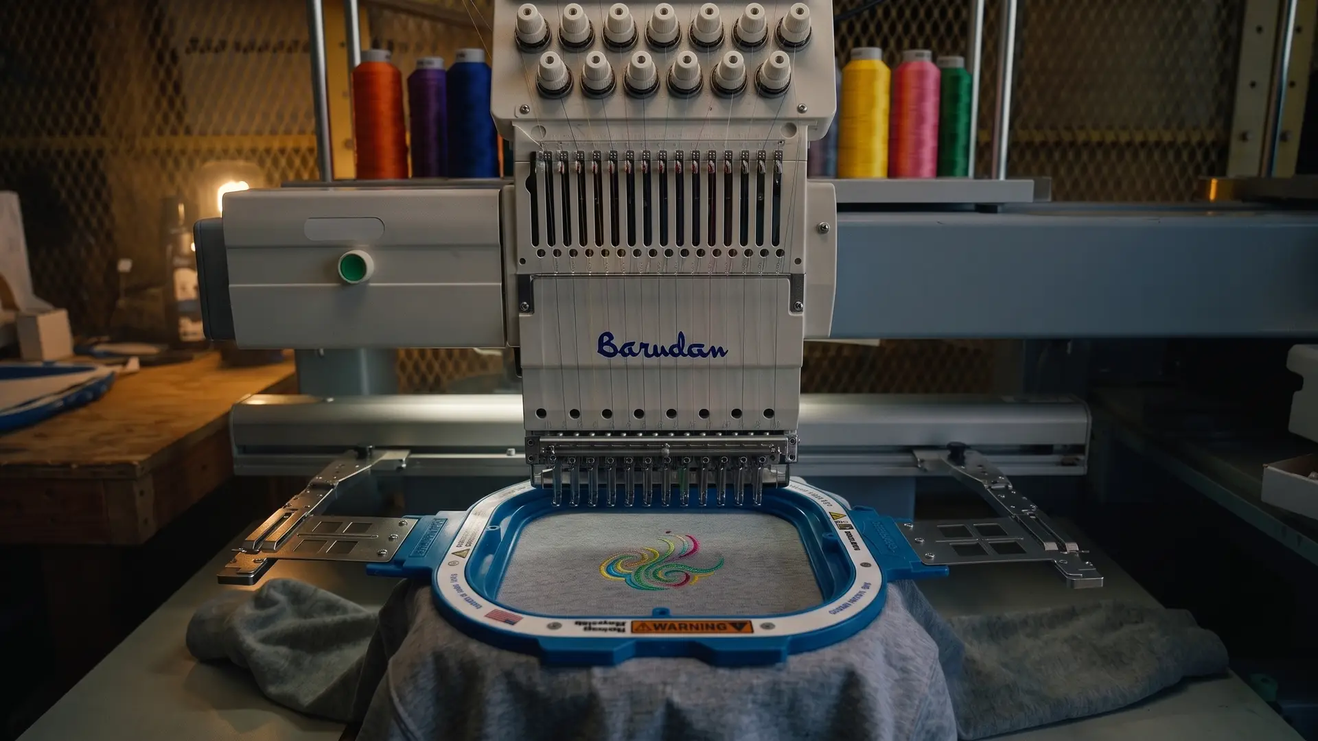 A Barudan multi-head embroidery machine stitching a navy cap